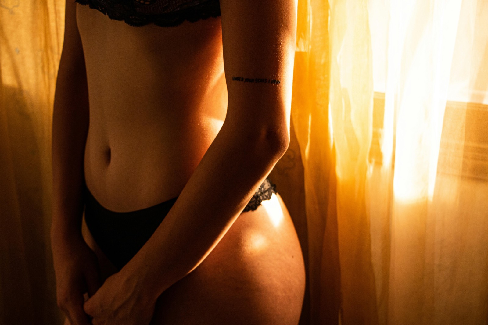 Warm low light across skin, the charged stillness before contact.